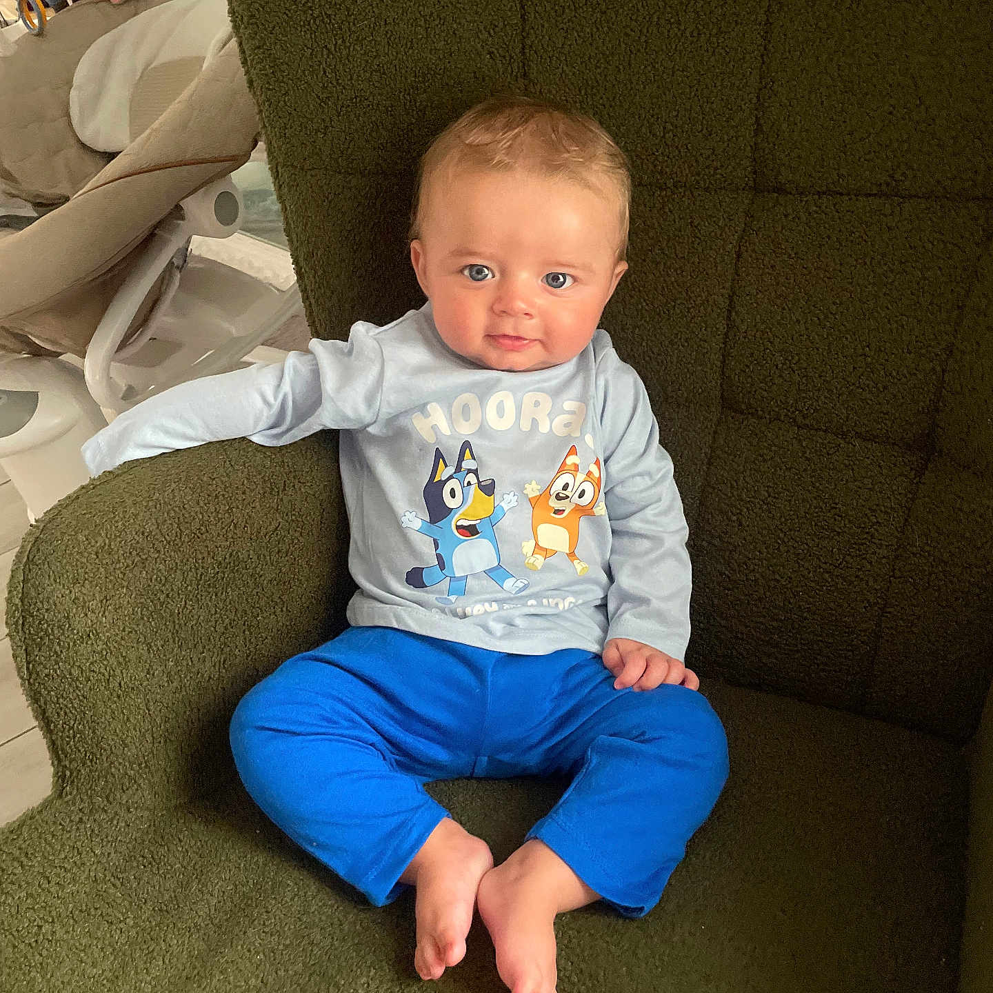 Kiezyo participe au concours pour gagner de l'argent avec cette photo : baby, barefoot, blue_eyes, blue_pants, cartoon_shirt, child, comfortable, cozy, curious, cute, green_chair, home_interior, indoor, innocent, portrait, sitting, smiling, soft_lighting, toddler, young_child