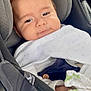 baby, car_seat, blanket, child, infant, face, person, clothing, seatbelt, car_interior, cute, young, head, smile, comfort, travel, safety, resting, indoors, portrait
