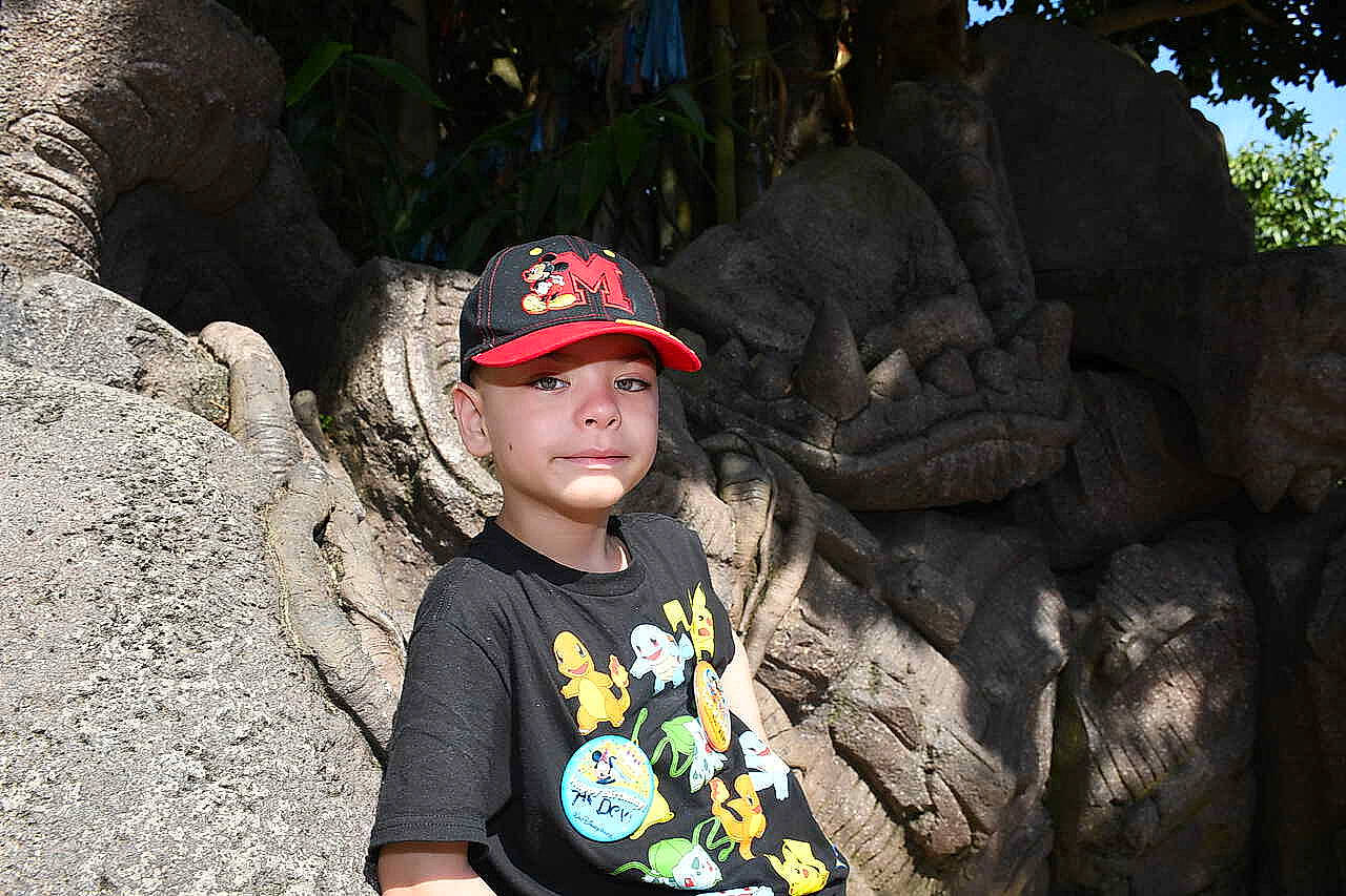 Devin joined the competition — help win amazing prizes! baseball_cap, bedrock, cap, flash_photography, formation, fun, glasses, hat, headwear, landscape, leaf, leisure, mammal, organism, person, recreation, rock, t_shirt, toddler, travel