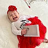 Raleigh is registered to the contest to win money with this photo: baby, smiling, red_headband, red_tutu, white_shirt, photo, lying_down, happy, infant, cute, portrait, indoor, child, headwear, fabric, hand, feet, skin, clothing, celebration