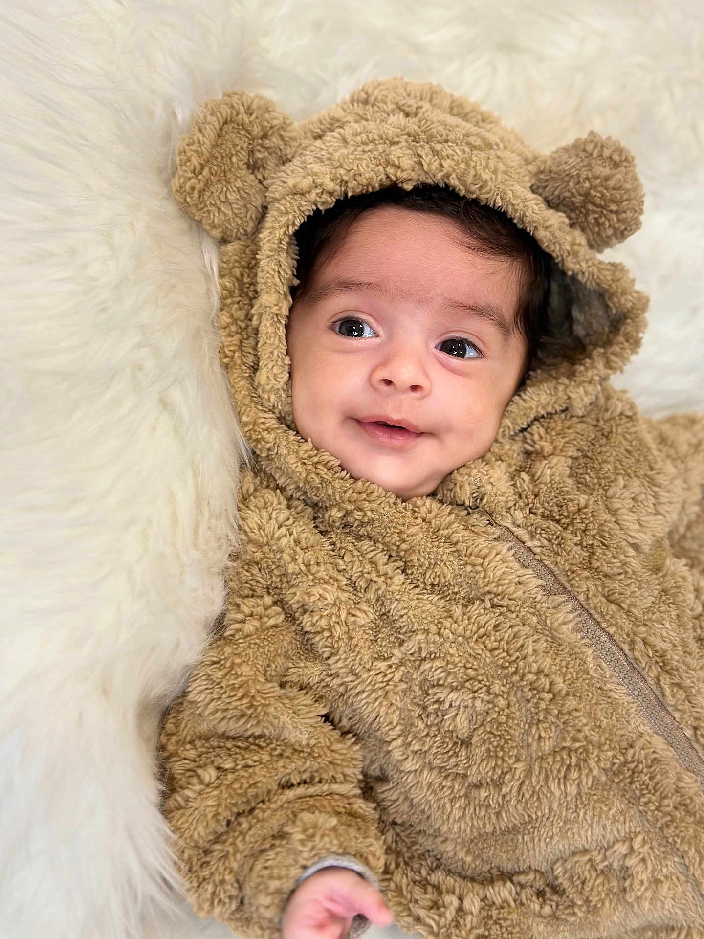 Theo is registered to the contest to win money with this photo: baby, child, infant, cute, smile, face, eyes, hood, bear_ears, onesie, furry, soft, warm, cozy, blanket, portrait, indoors, young, happy, closeup