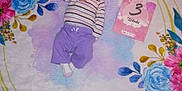 Serenity is registered to the contest to win money with this photo: 3_weeks, baby, blanket, cute, early_life, face, floral_pattern, head, indoors, infant, lying_down, milestone_card, newborn, peaceful, person, purple_pants, small, socks, soft_texture, striped_shirt