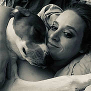 Red Maynes is registered to the contest to win money with this photo: dog, person, face, embrace, black_and_white, close_up, bed, cuddle, pet, love, relaxation, comfort, intimate, animal, human, portrait, sleepy, affection, friendship, cozy
