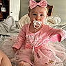baby, child, pink_clothing, headband, pacifier, tutu_skirt, socks, bed, blanket, butterfly, furniture, shelf, door, person, indoors, cute, infant, home, soft_toys, portrait