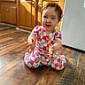 Delilah joined the competition — help win amazing prizes! baby, child, curly_hair, colorful_clothing, checkered_pattern, wooden_floor, kitchen, cabinets, happy, smiling, sitting, indoors, person, cute, playful, toddler, reaching_out, bright, natural_light, floor