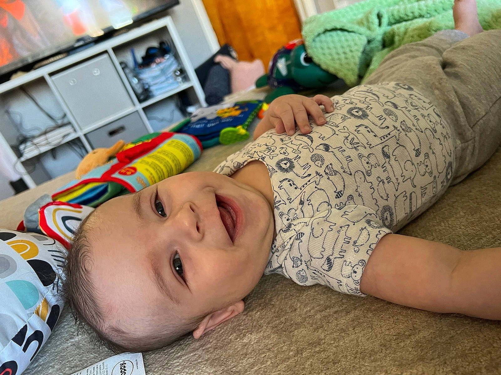 Finn is registered to the contest to win money with this photo: baby, cabinetry, comfort, couch, elbow, hand, happy, human_leg, joint, joy, kitchen_appliance, mammal, mouth, neck, organ, person, refrigerator, skin, smile, textile