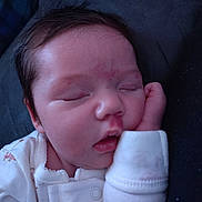 E'Milia is registered to the contest to win money with this photo: baby, newborn, sleeping, face, closed_eyes, onesie, hand, cheek, hair, infant, portrait, peaceful, skin, mouth, nose, eyelids, pajamas, bed, blanket, cuddled