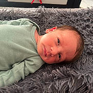 Zéphyr participe au concours pour gagner de l'argent avec cette photo : baby, blanket, child, closeup, cozy, cute, expression, face, green_clothing, head, indoors, infant, lying_down, newborn, person, resting, skin, sleepy, soft_texture, young