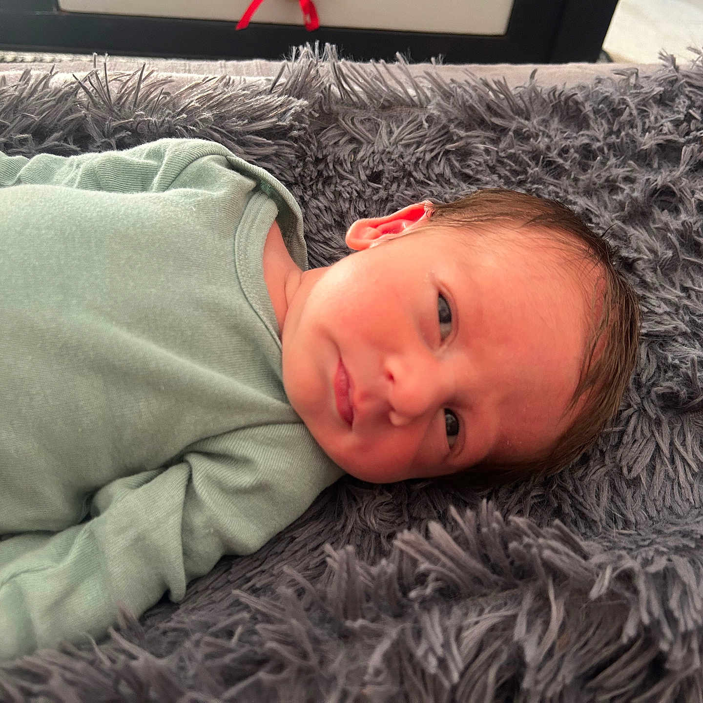 Zéphyr participe au concours pour gagner de l'argent avec cette photo : baby, blanket, child, closeup, cozy, cute, expression, face, green_clothing, head, indoors, infant, lying_down, newborn, person, resting, skin, sleepy, soft_texture, young