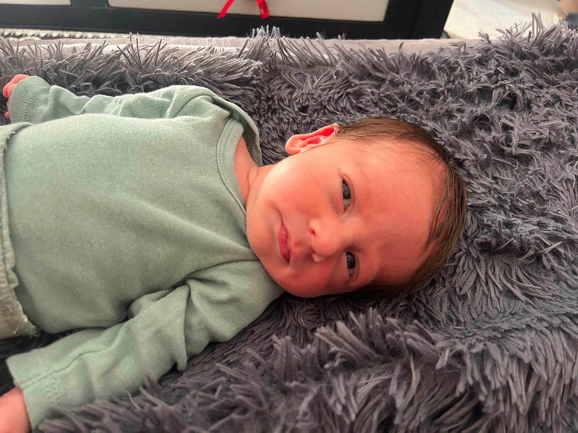 Zéphyr participe au concours pour gagner de l'argent avec cette photo : baby, blanket, child, closeup, cozy, cute, expression, face, green_clothing, head, indoors, infant, lying_down, newborn, person, resting, skin, sleepy, soft_texture, young