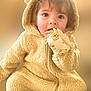 child, toddler, cute, fluffy, hooded_jumpsuit, bear_ears, mittens, face, blue_eyes, curly_hair, soft_texture, warm_colors, portrait, indoor, baby_clothing, closeup, adorable, young_child, smiling_eyes, cozy