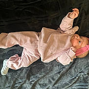 Milly joined the competition — help win amazing prizes! baby, infant, pink_clothing, headband, lying_down, blanket, soft_texture, curious, small_hands, footwear, cozy, indoors, cute, child, portrait, resting, young, one_person, casual, comfortable
