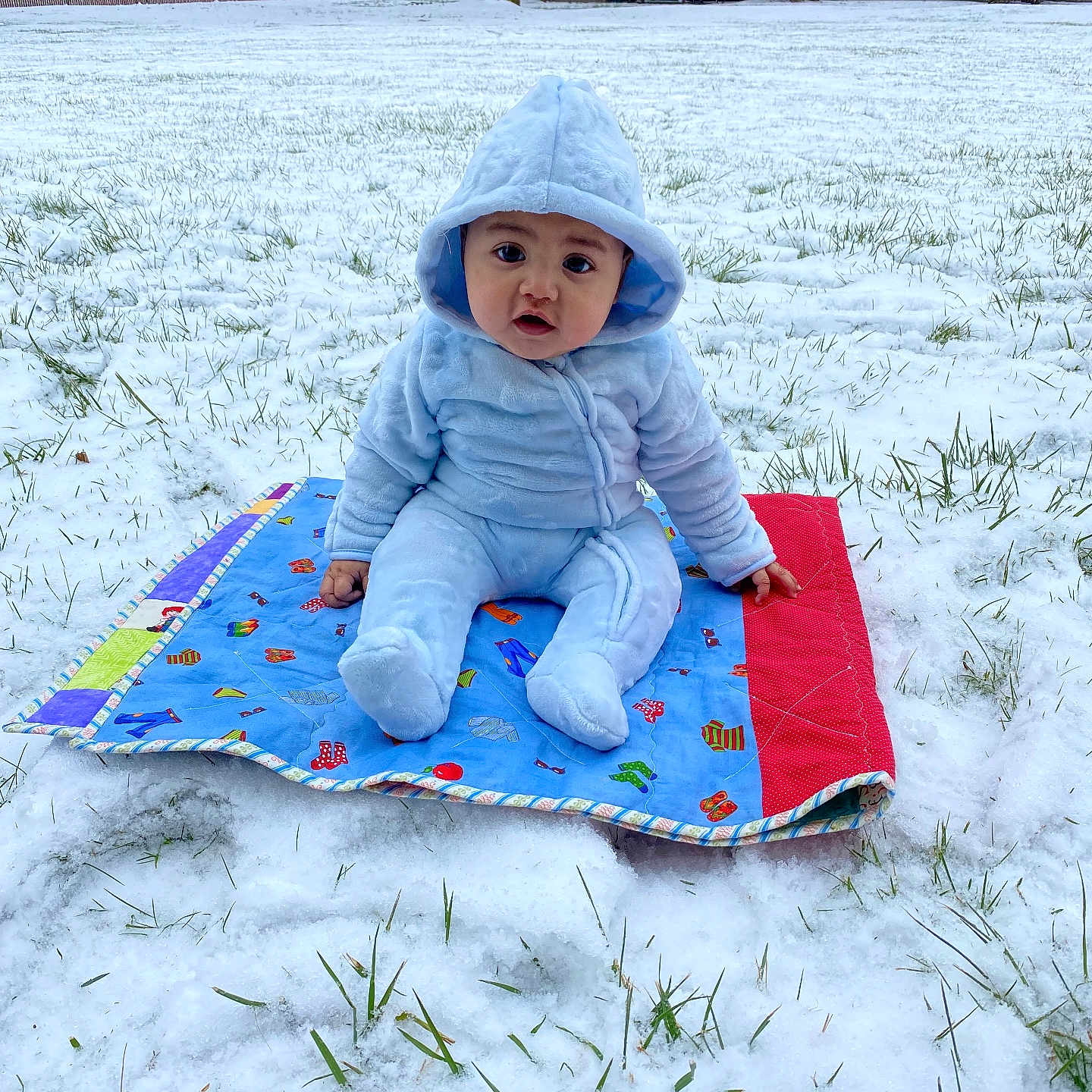 Elias De Luna joined the competition — help win amazing prizes! baby, blanket, blue_clothing, child, cold, curious, cute, daylight, grass, hood, house, infant, nature, outdoor, person, playtime, sitting, snow, winter, yard