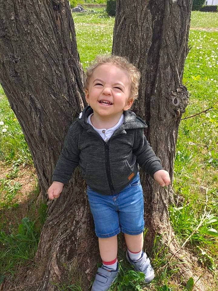 Bryan participe au concours pour gagner de l'argent avec cette photo : baby_toddler_clothing, boot, botany, child, electric_blue, forest, gesture, grass, happy, joy, natural_landscape, people_in_nature, person, plant, smile, toddler, tree, trunk, wood, woodland