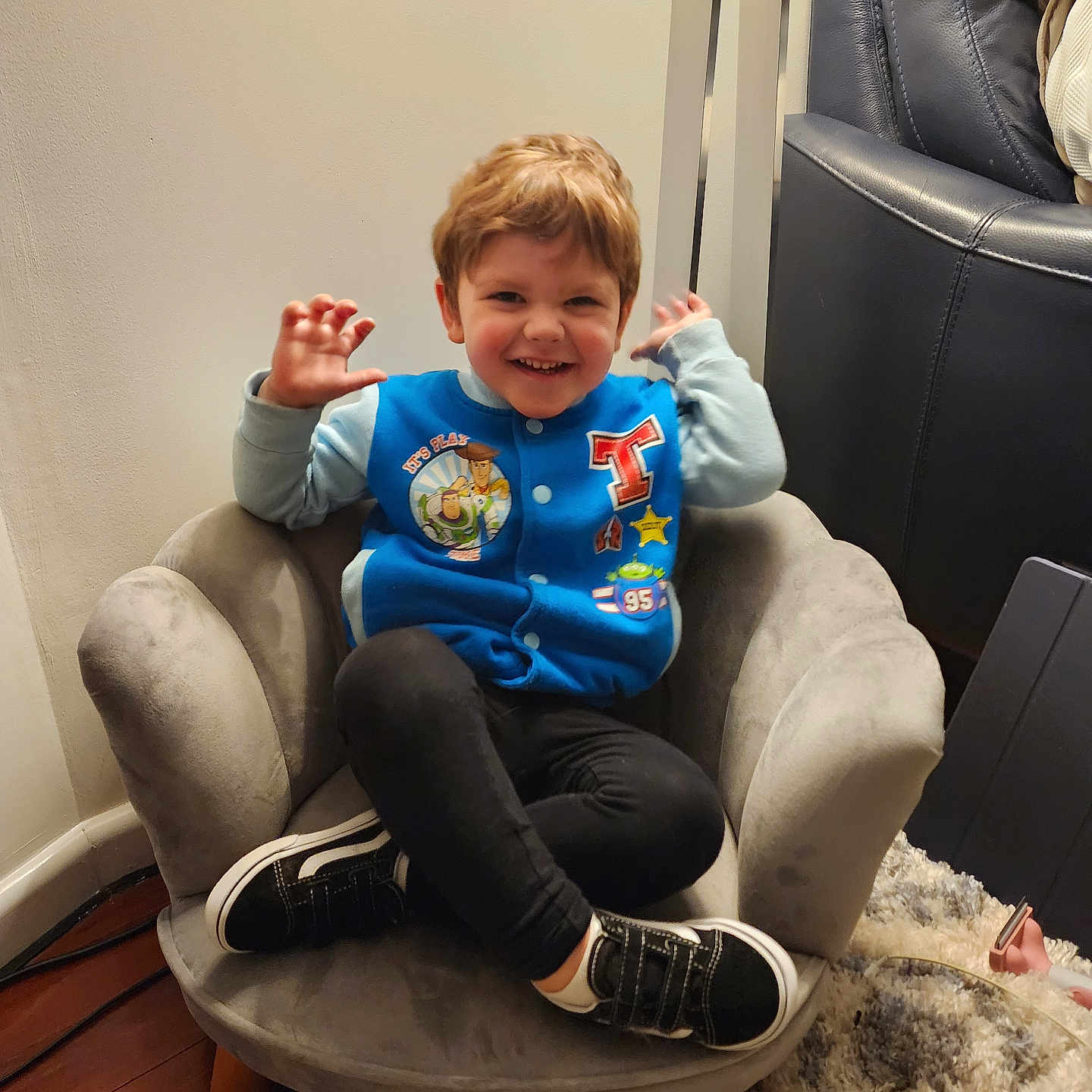 Spencer joined the competition — help win amazing prizes! armchair, blue_jacket, carpet, casual_clothing, child, cozy, crossed_legs, cute, expression, furniture, hair, happy, indoor, person, playful, seated, smiling, sneakers, wood_floor, young_child