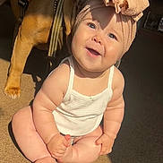Giovanna is registered to the contest to win money with this photo: baby, child, infant, smiling, headband, bow, dog, pet, carpet, sunlight, indoor, cute, happy, sitting, skin, hand, foot, animal, companion, playful