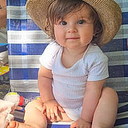 Aria a rejoint le concours — aidez-le/la à gagner de superbes lots ! baby, child, hat, onesie, striped_chair, outdoor, smiling, cute, barefoot, toddler, sunlight, portrait, sitting, happy, skin, hand, foot, face, hair, person