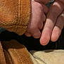 baby_hand, adult_hand, holding, brown_clothing, beige_clothing, close_up, skin, texture, soft_fabric, intimacy, connection, fingers, warm_colors, tender_moment, human_skin, child, parent, love, care, touch