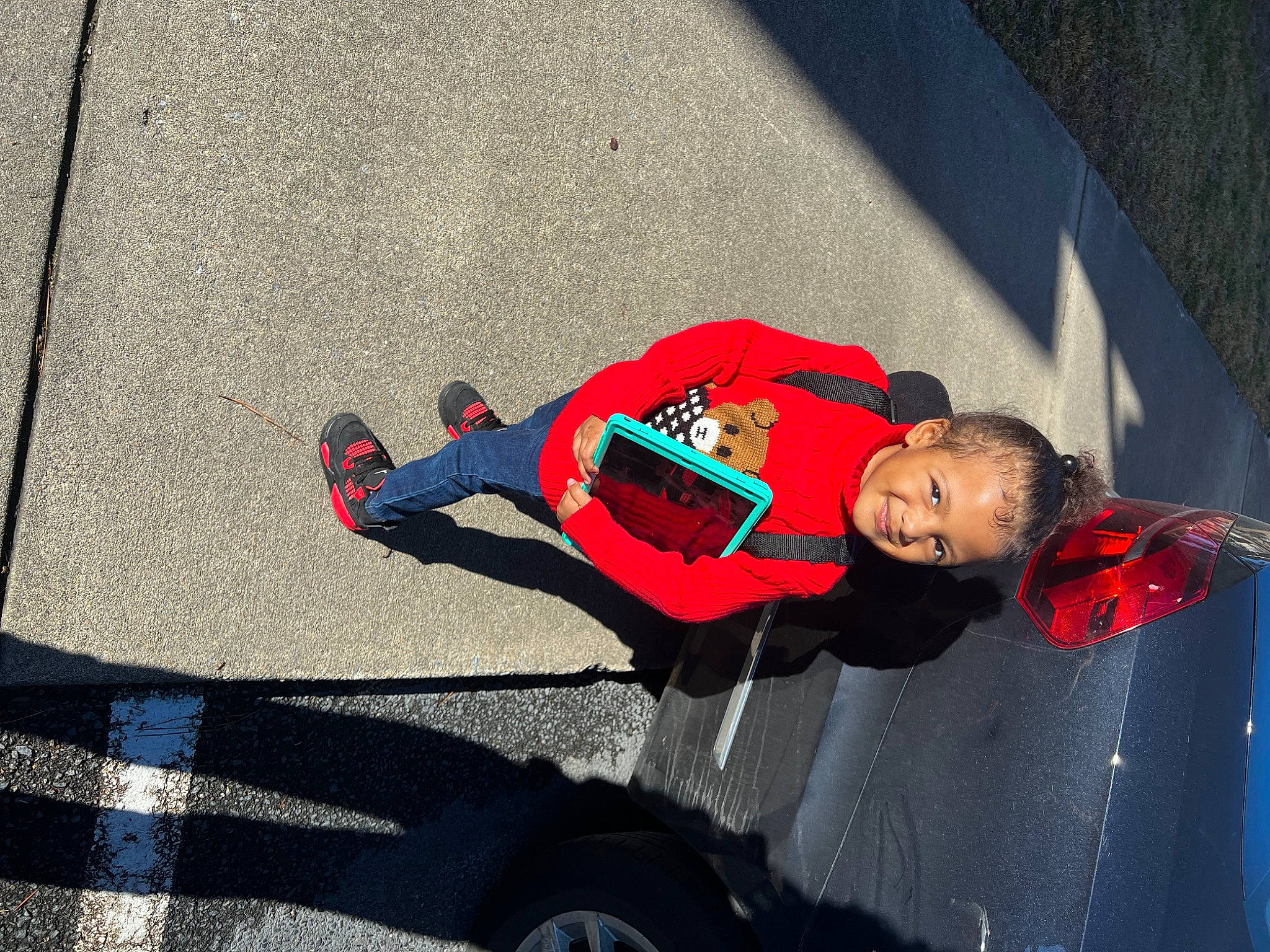 Ivy is registered to the contest to win money with this photo: asphalt, automotive_exterior, automotive_tire, automotive_wheel_system, bumper, carmine, concrete, electric_blue, fun, joy, person, recreation, rim, road_surface, rolling, sidewalk, tire, toddler, vehicle_door, walking_shoe