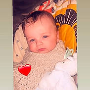 Kaige-Ray is registered to the contest to win money with this photo: baby, infant, blanket, knitted, plush_toy, pacifier, heart_emoji, blue_eyes, face, cute, child, indoor, portrait, lying_down, soft_toy, warm_colors, young_child, comfort, sleepy, adorable