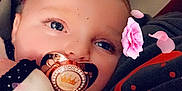 Scarlett-Ann joined the competition — help win amazing prizes! baby, pacifier, blue_eyes, flower_petal, pink_flower, close_up, infant, cute, soft_lighting, face, child, indoor, cozy, blanket, dots, person, digital_effect, adorable, portrait, young_child