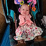 baby, baby_accessory, boots, car_seat, child, clothing, cute, dress, face, footwear, hanging_toys, happy, indoor, infant, person, pink_cardigan, portrait, seatbelt, smiling, toy