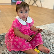 Bella is registered to the contest to win money with this photo: child, toddler, baby, portrait, sitting, indoors, pink_dress, polka_dots, flower_hair_clip, hairbrush, rug, carpet, wooden_floor, home, furniture, smiling, wide_eyed, barefoot, fashion, photography