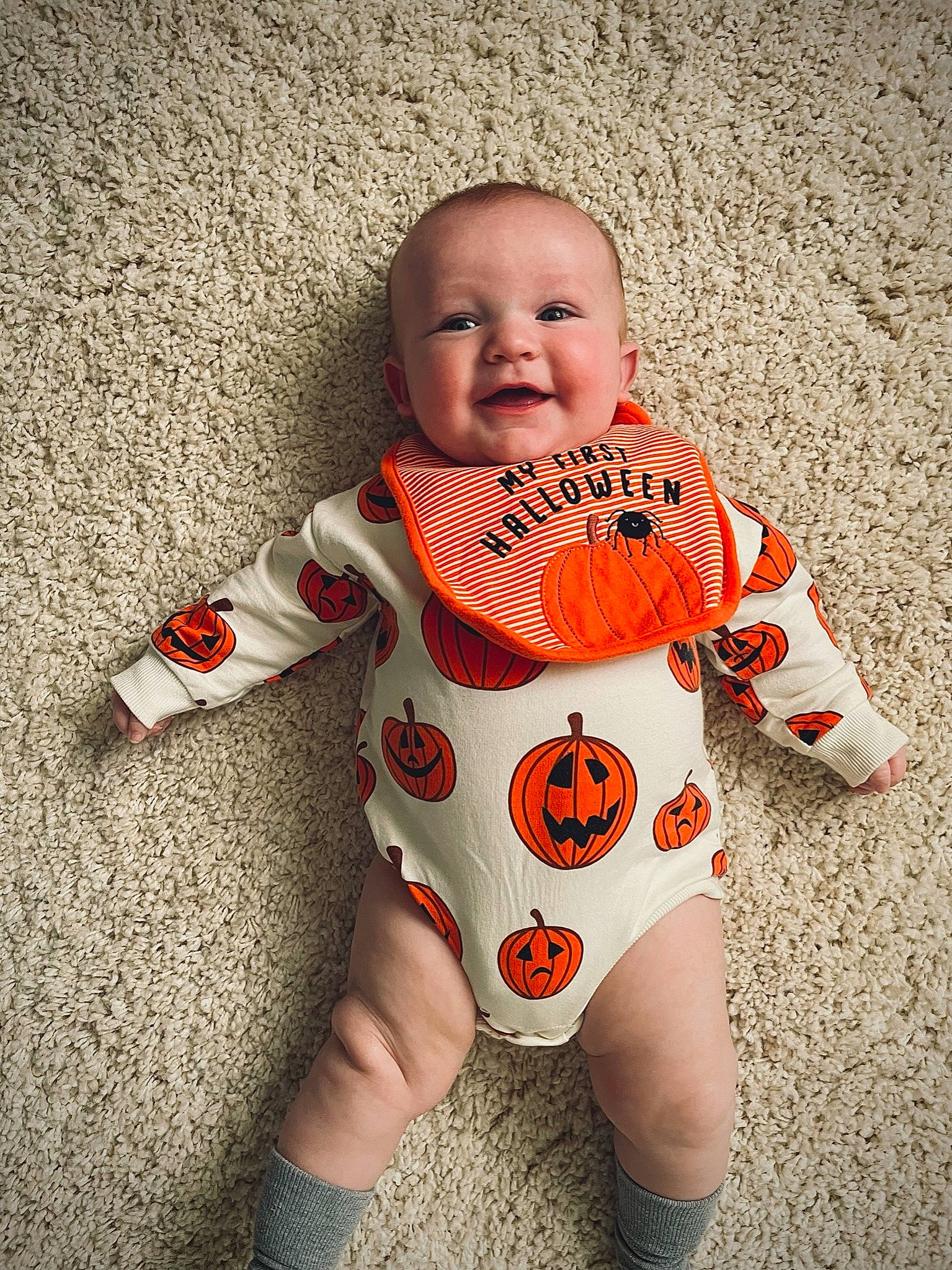 Owen is registered to the contest to win money with this photo: baby, baby_toddler_clothing, cheek, eye, face, facial_expression, finger, floor, flooring, happy, head, human_body, leg, orange, person, skin, sleeve, smile, t_shirt, toddler