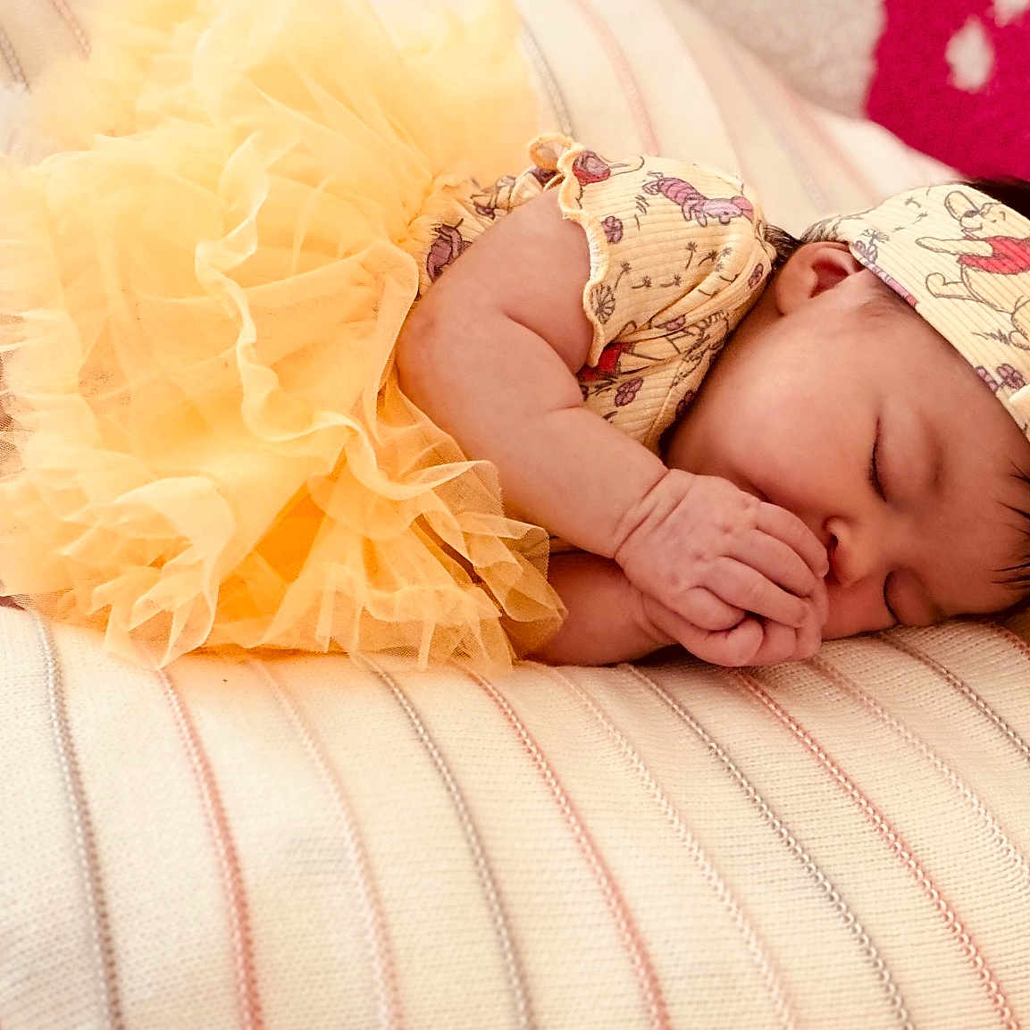 Haizly is registered to the contest to win money with this photo: baby, bedroom, cartoon_print, closeup, cozy, cute, fabric, foot, hand, headband, infant, peaceful, pillow, portrait, resting, sleeping, soft_lighting, striped, tutu, yellow