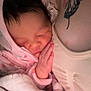 baby, newborn, sleeping, pink_hoodie, blanket, tattoo, butterfly_tattoo, arm, skin, soft_texture, peaceful, closeup, infant, resting, cute, warmth, parent, love, comfort, snuggle