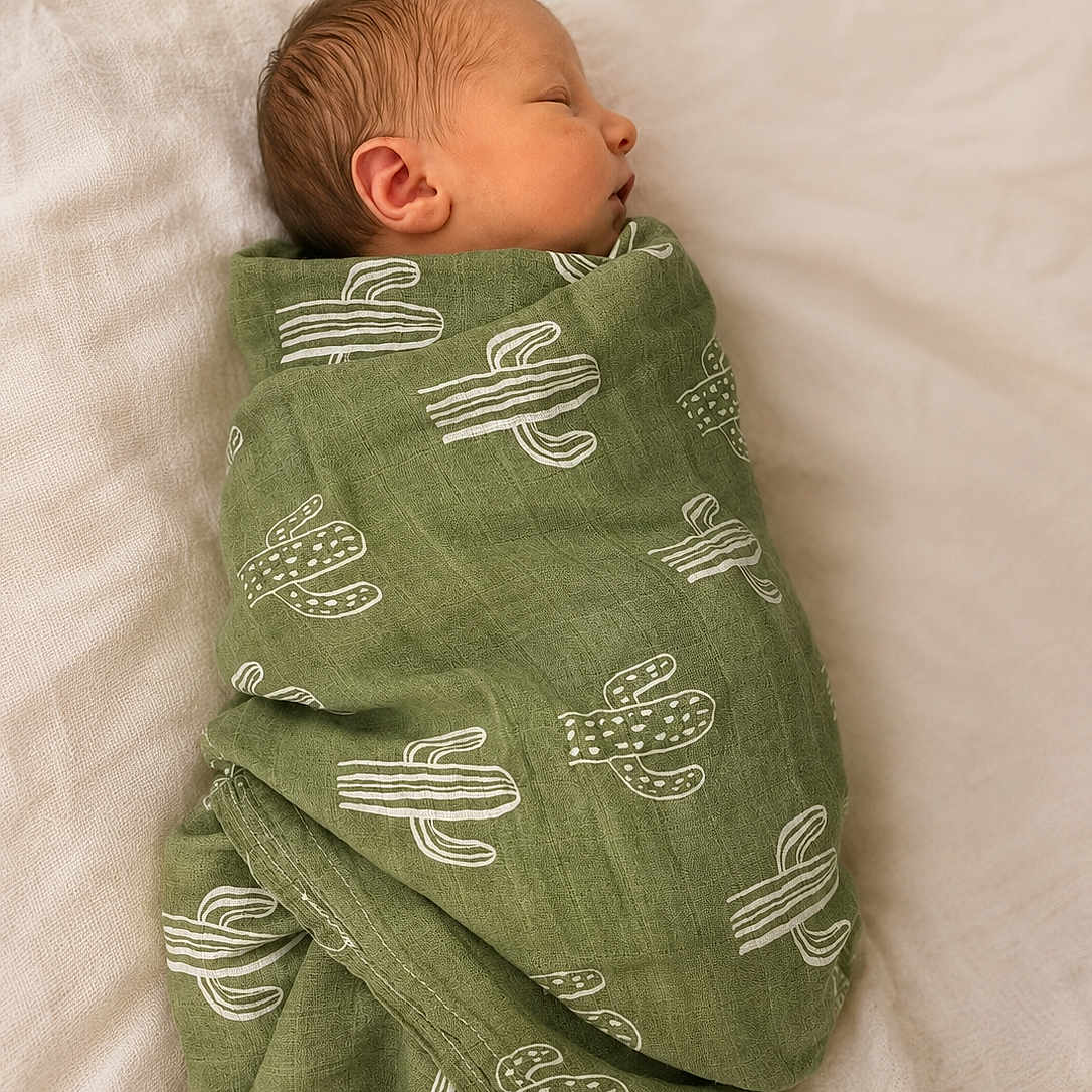 Jagger is registered to the contest to win money with this photo: newborn, baby, sleeping, blanket, green, cactus_pattern, wrapped, infant, soft, peaceful, portrait, bed, resting, cute, child, young, lying_down, cozy, warm, sleep