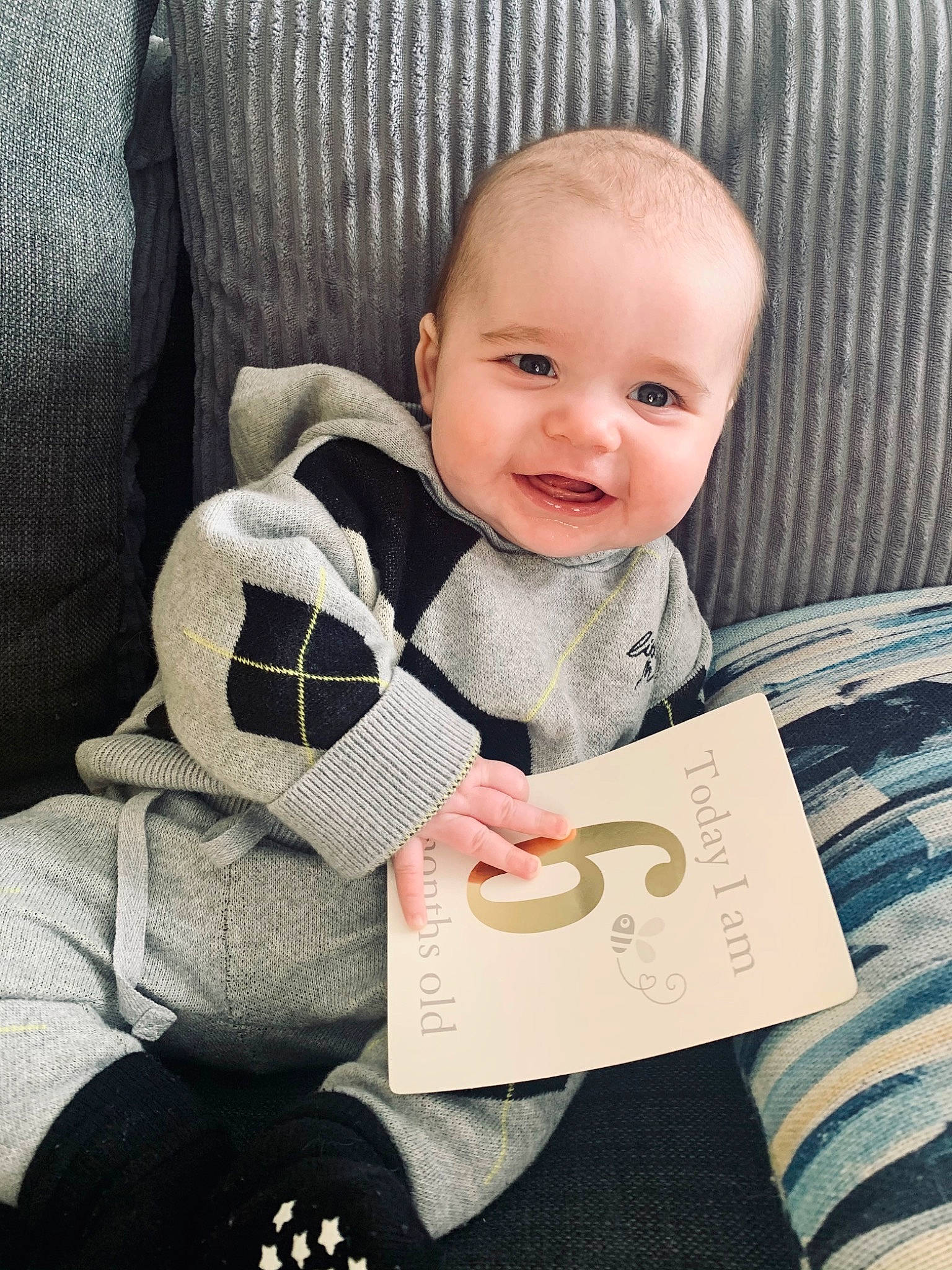 Grayson is registered to the contest to win money with this photo: arm, baby, baby_in_car_seat, baby_products, baby_toddler_clothing, cheek, child, collar, comfort, eye, face, facial_expression, head, linens, person, sitting, sleeve, smile, t_shirt, textile