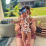 Genesis joined the competition — help win amazing prizes! baby, child, person, smiling, bow, outdoor, porch, pillow, cushion, swing, summer, dress, pattern, house, greenery, tree, grass, bracelet, happy, sunlight