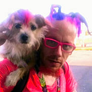 Bella Louise is registered to the contest to win money with this photo: person, dog, glasses, hair, colorful, blurry, outdoor, shoulder, pet, casual, portrait, fun, bright_colors, lanyard, facial_hair, fur, closeup, human, accessory, expression