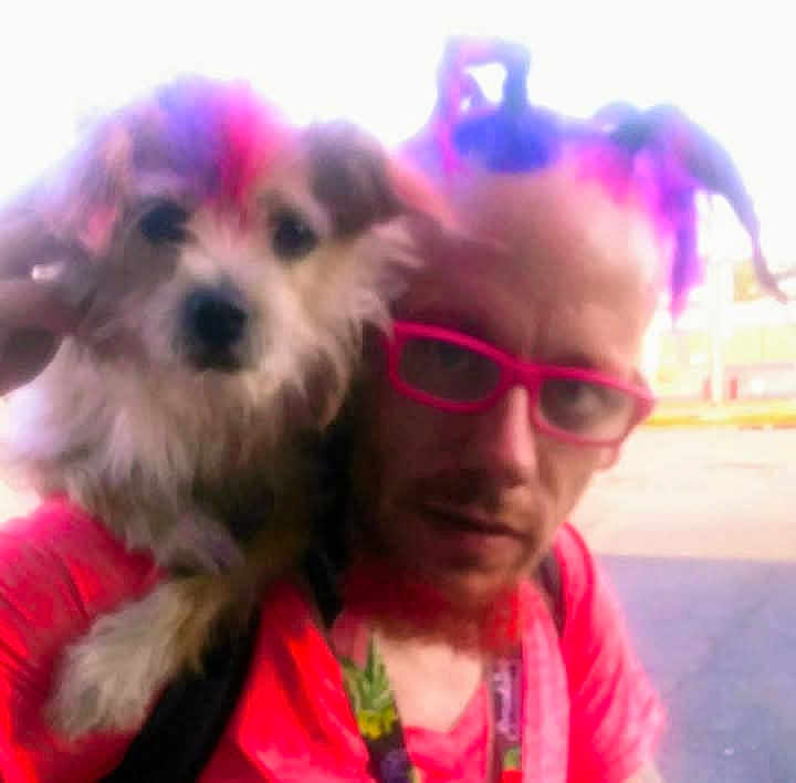 Bella Louise is registered to the contest to win money with this photo: person, dog, glasses, hair, colorful, blurry, outdoor, shoulder, pet, casual, portrait, fun, bright_colors, lanyard, facial_hair, fur, closeup, human, accessory, expression