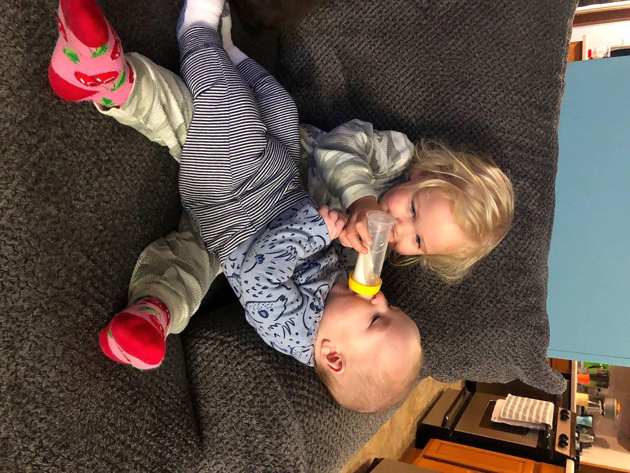 Juliet is registered to the contest to win money with this photo: baby, baby_toddler_clothing, black, carmine, child, comfort, computer_keyboard, desk, finger, flooring, foot, fun, human_leg, office_equipment, person, play, room, sitting, sock, table