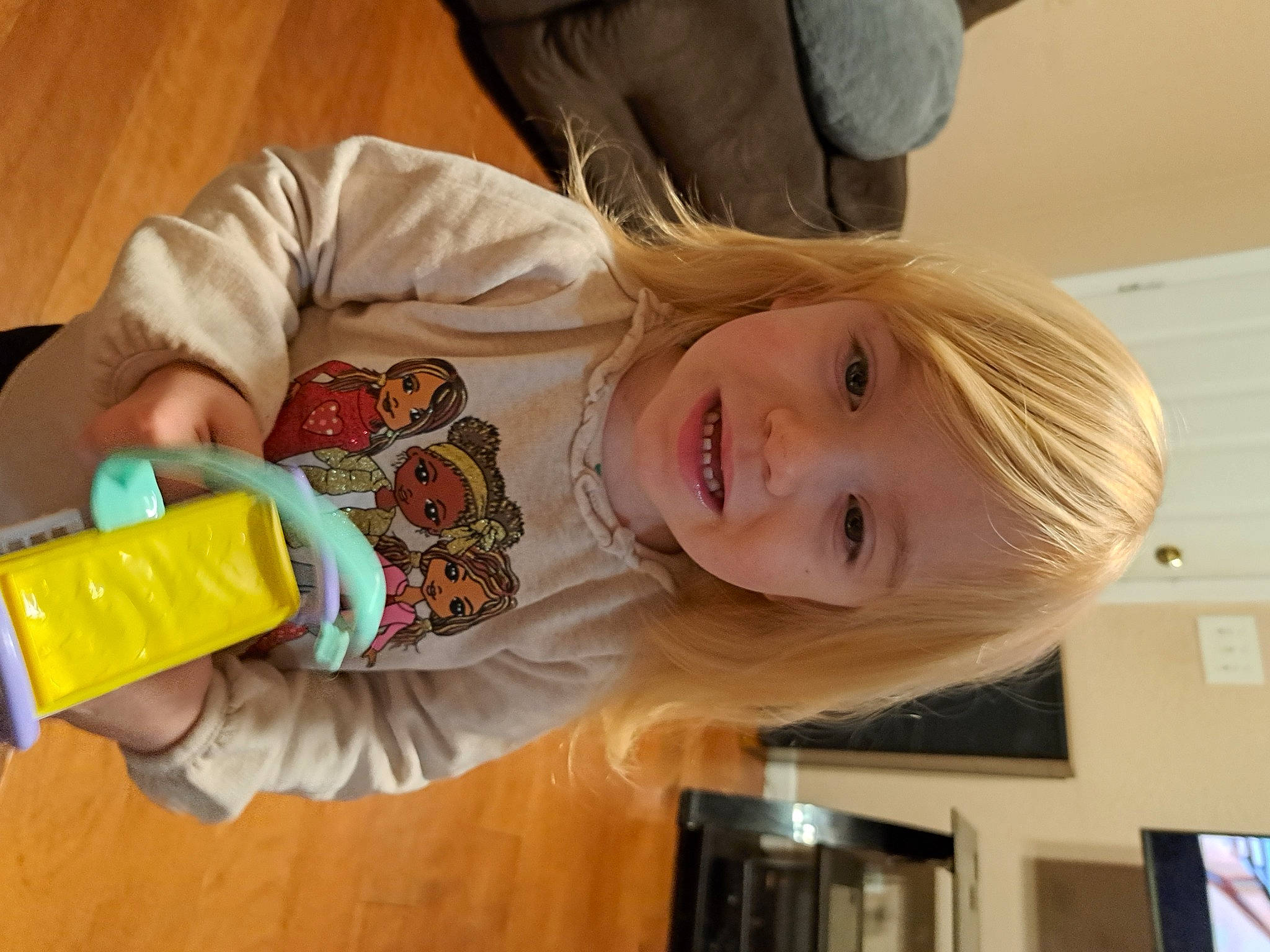 Persephany joined the competition — help win amazing prizes! bangs, blond, child, drink, drinkware, fun, happy, joy, person, picture_frame, plastic, plastic_bottle, play, room, smile, table, toddler, vacation, varnish, wood