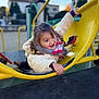 Esmée participe au concours pour gagner de l'argent avec cette photo : child, girl, playground, yellow, coat, scarf, happy, outdoor, play, smile, curly_hair, winter_clothing, daylight, fun, climbing, young, person, park, activity, joy