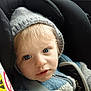 toddler, child, face, blue_eyes, hat, car_seat, seatbelt, jacket, clothing, baby, portrait, close_up, indoors, seat, child_safety, winter_wear, expression, cute, young_child, headwear