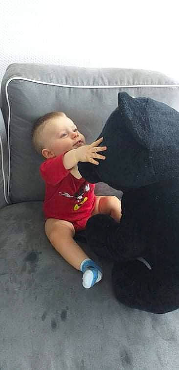 Kyllian a rejoint le concours — aidez-le/la à gagner de superbes lots ! baby, baby_toddler_clothing, child, comfort, couch, finger, flooring, foot, fun, hairstyle, human_leg, knee, lap, leg, person, pillow, sitting, t_shirt, thigh, toddler