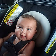 Ivy is registered to the contest to win money with this photo: baby, car_seat, smiling, child, infant, safety_harness, cute, portrait, seat_belt, warning_label, happy, face, skin, person, baby_chair, closeup, head_support, indoor, newborn, child_safety