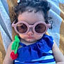 Mikayla joined the competition — help win amazing prizes! child, baby, sunglasses, curly_hair, blue_outfit, striped_clothing, cherry_decoration, towel, outdoor, summer, cute, relaxed, infant, person, fashion, accessory, portrait, closeup, skin, headwear