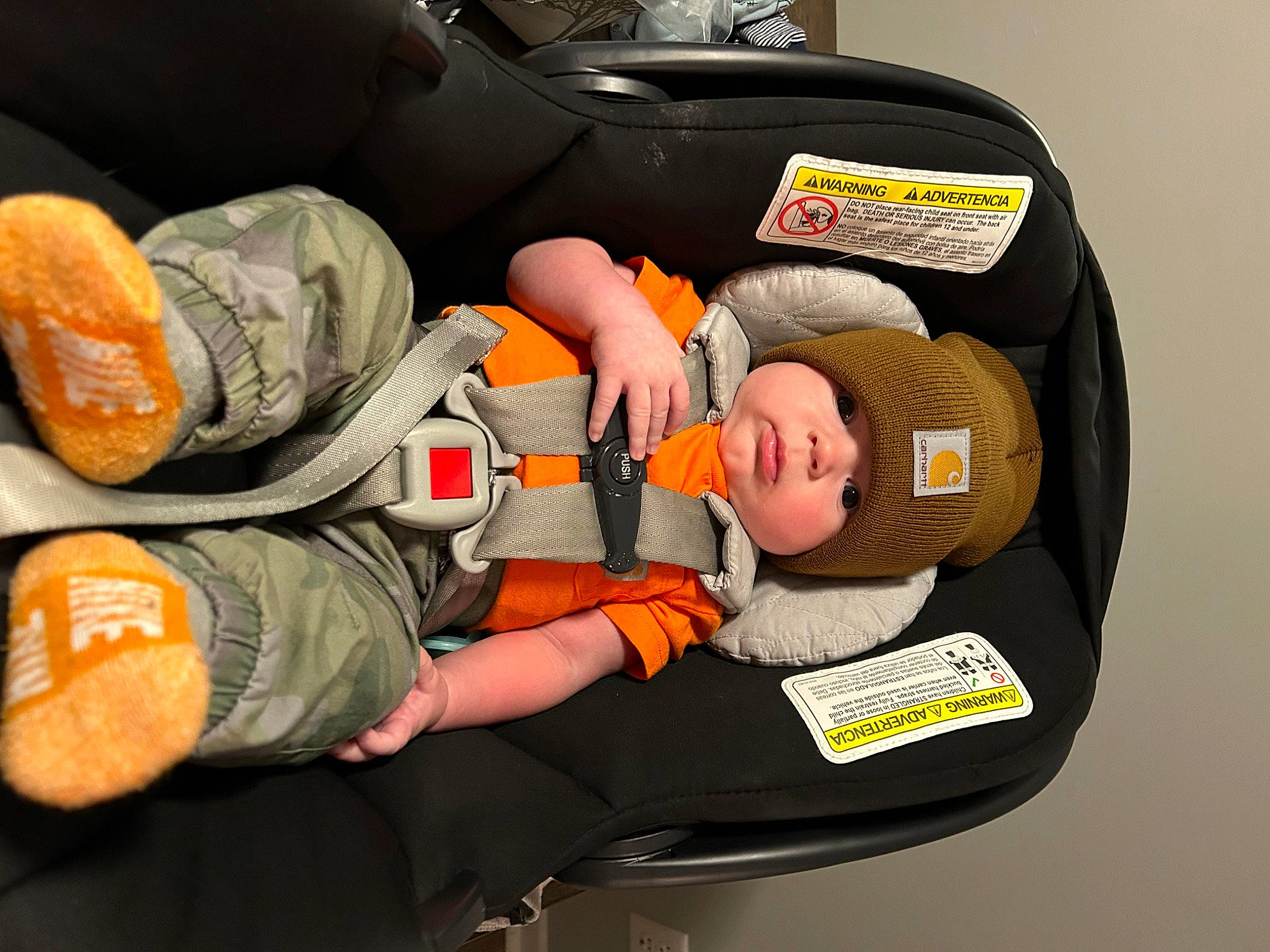 Boe is registered to the contest to win money with this photo: auto_part, baby, baby_carriage, baby_products, baby_sleeping, baby_toddler_clothing, bag, baggage, car_seat, child, comfort, headwear, lap, luggage_and_bags, orange, person, service, sitting, toddler