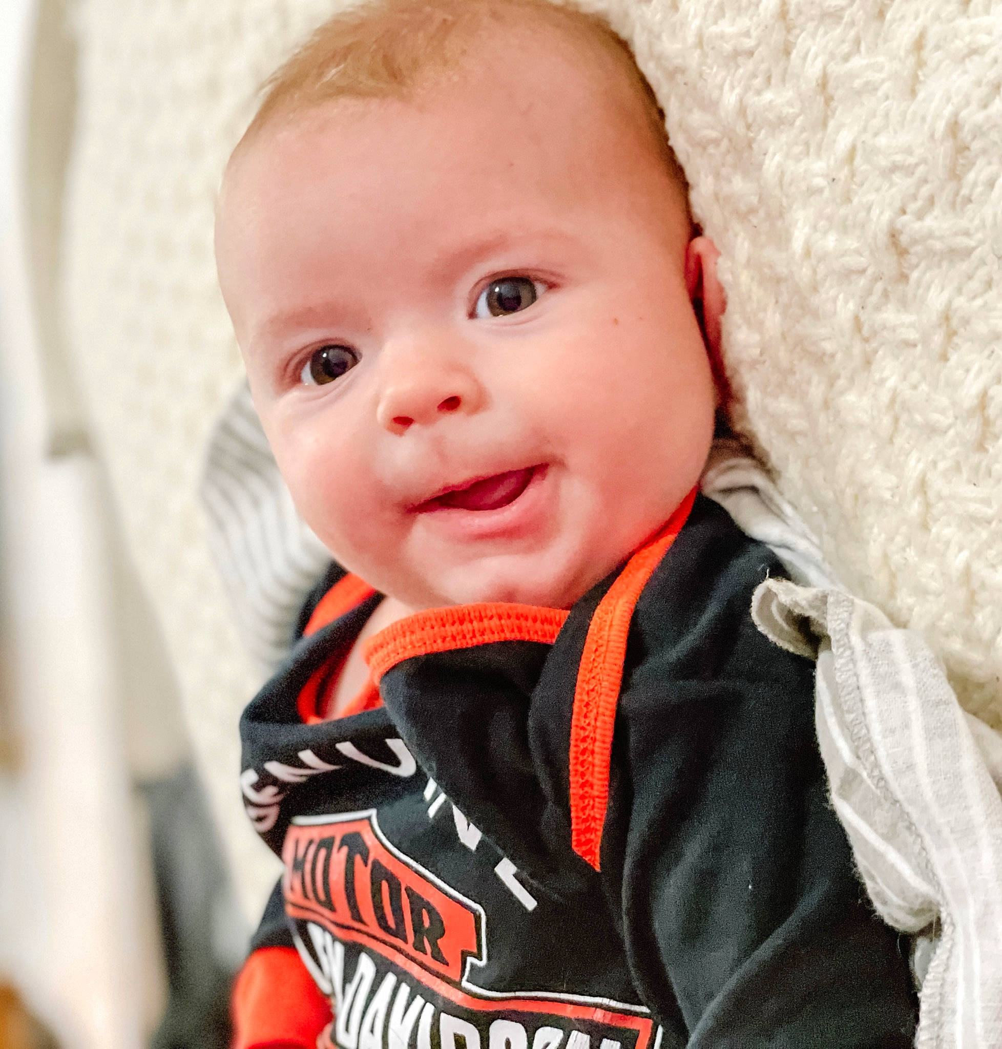 Boe is registered to the contest to win money with this photo: baby, baby_toddler_clothing, cheek, child, chin, collar, comfort, face, flash_photography, fun, happy, iris, nose, person, personal_protective_equipment, portrait_photography, sitting, sleeve, smile, t_shirt