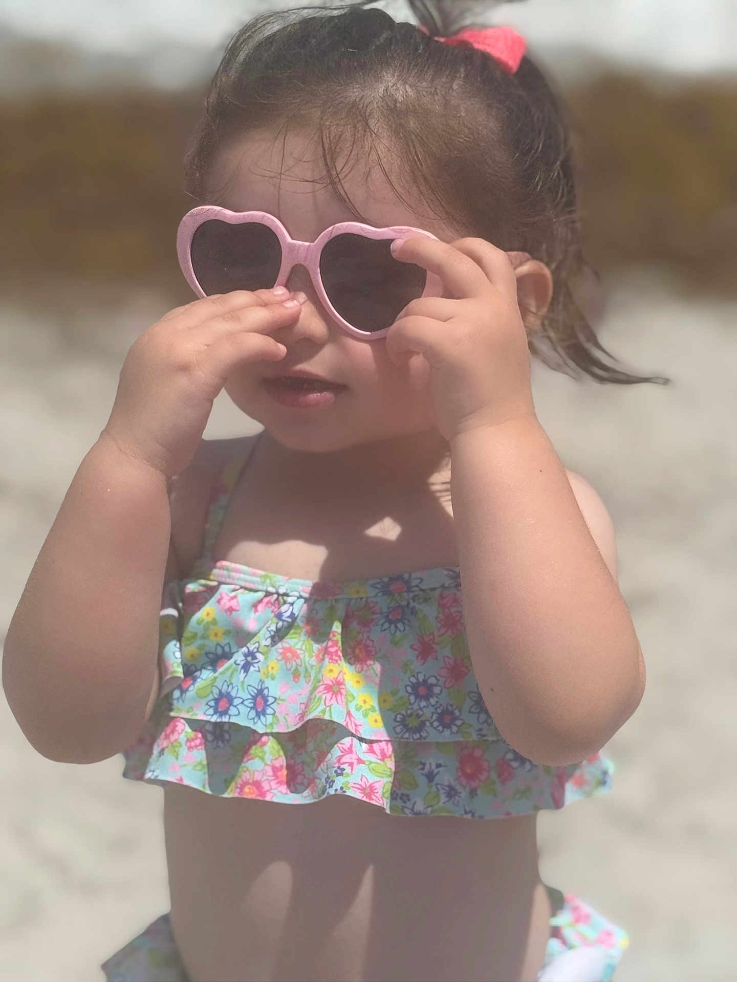 Taliah joined the competition — help win amazing prizes! child, toddler, sunglasses, heart_shaped, swimsuit, floral_pattern, beach, sunny, outdoor, summer, hair_tie, pink, playing, sunlight, cute, fashion, portrait, person, skin, hands