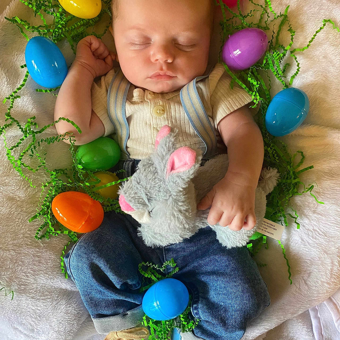 Bryson is registered to the contest to win money with this photo: baby, blanket, clothing, egg, face, food, footwear, grass, head, jeans, newborn, pants, person, photography, plant, portrait, purple, shoe, sleeping, sweets