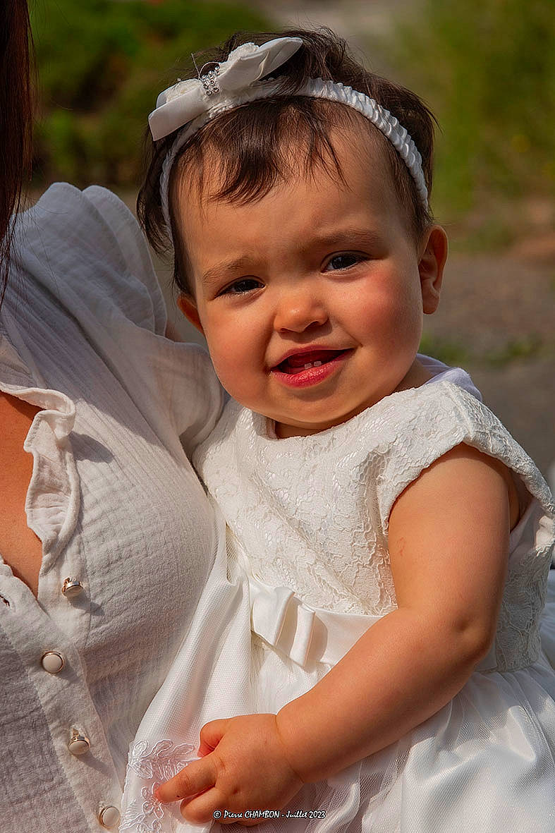 Nelia a rejoint le concours — aidez-le/la à gagner de superbes lots ! baby, baby_toddler_clothing, bridal_accessory, bridal_clothing, child, facial_expression, fun, gesture, grass, hairstyle, happy, human, iris, joy, neck, people, people_in_nature, person, skin, sleeve