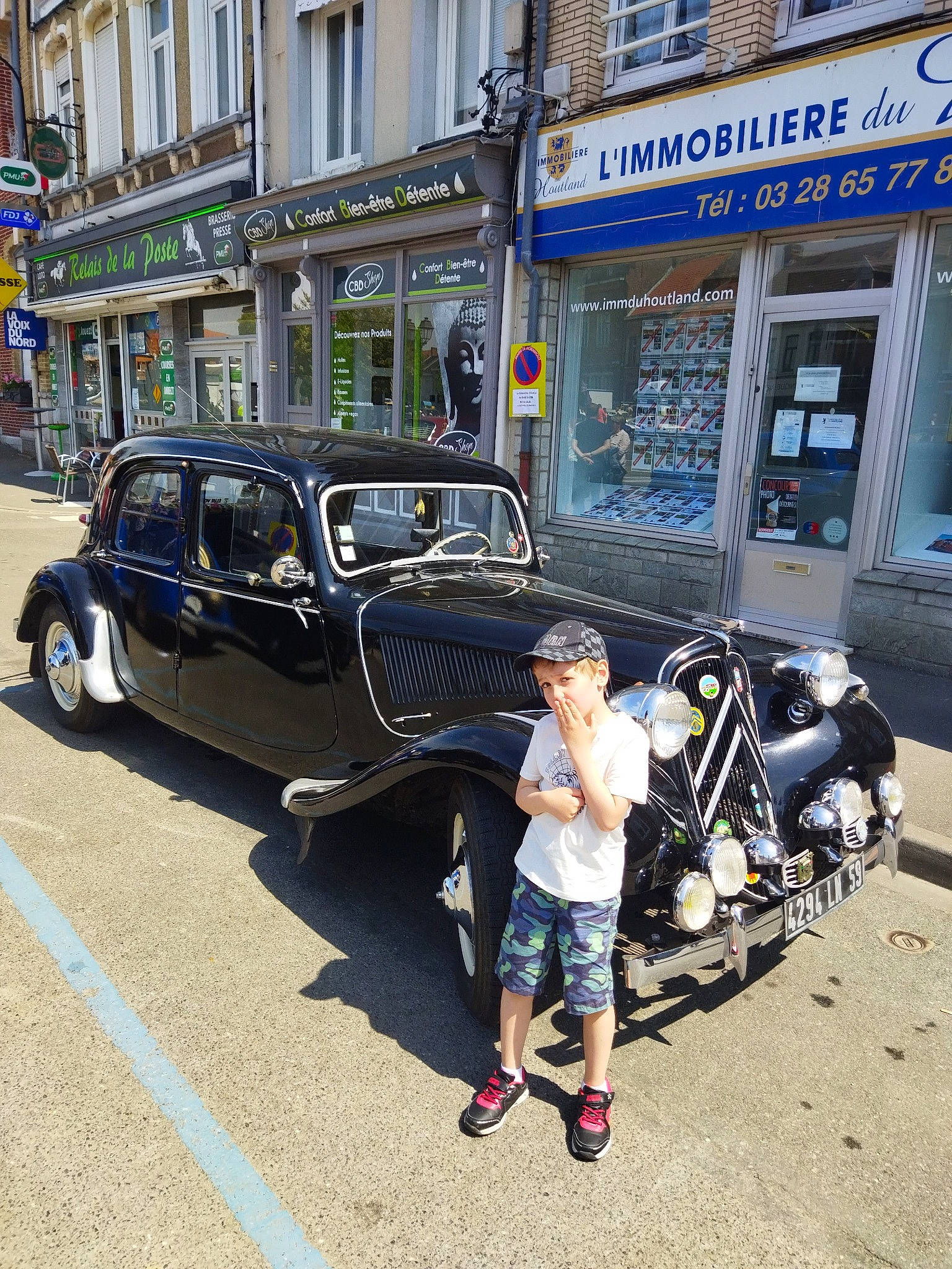 Nathéo participe au concours pour gagner de l'argent avec cette photo : asphalt, automotive_design, automotive_exterior, building, car, city, classic, classic_car, clothing, headwear, mode_of_transport, motor_vehicle, parking, person, road, shorts, street_fashion, tire, travel, vehicle