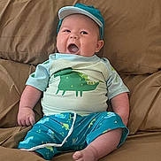 Rayden joined the competition — help win amazing prizes! baby, cap, child, clothing, comfortable, couch, cute, dinosaur, funny_face, furniture, happy, indoors, infant, person, portrait, relaxing, shorts, sitting, smile, tshirt