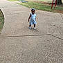 toddler, child, sidewalk, park, grass, playground_equipment, headband, striped_clothing, outdoor, summer, footwear, tree, concrete, person, young_child, standing, casual, daytime, nature, recreation